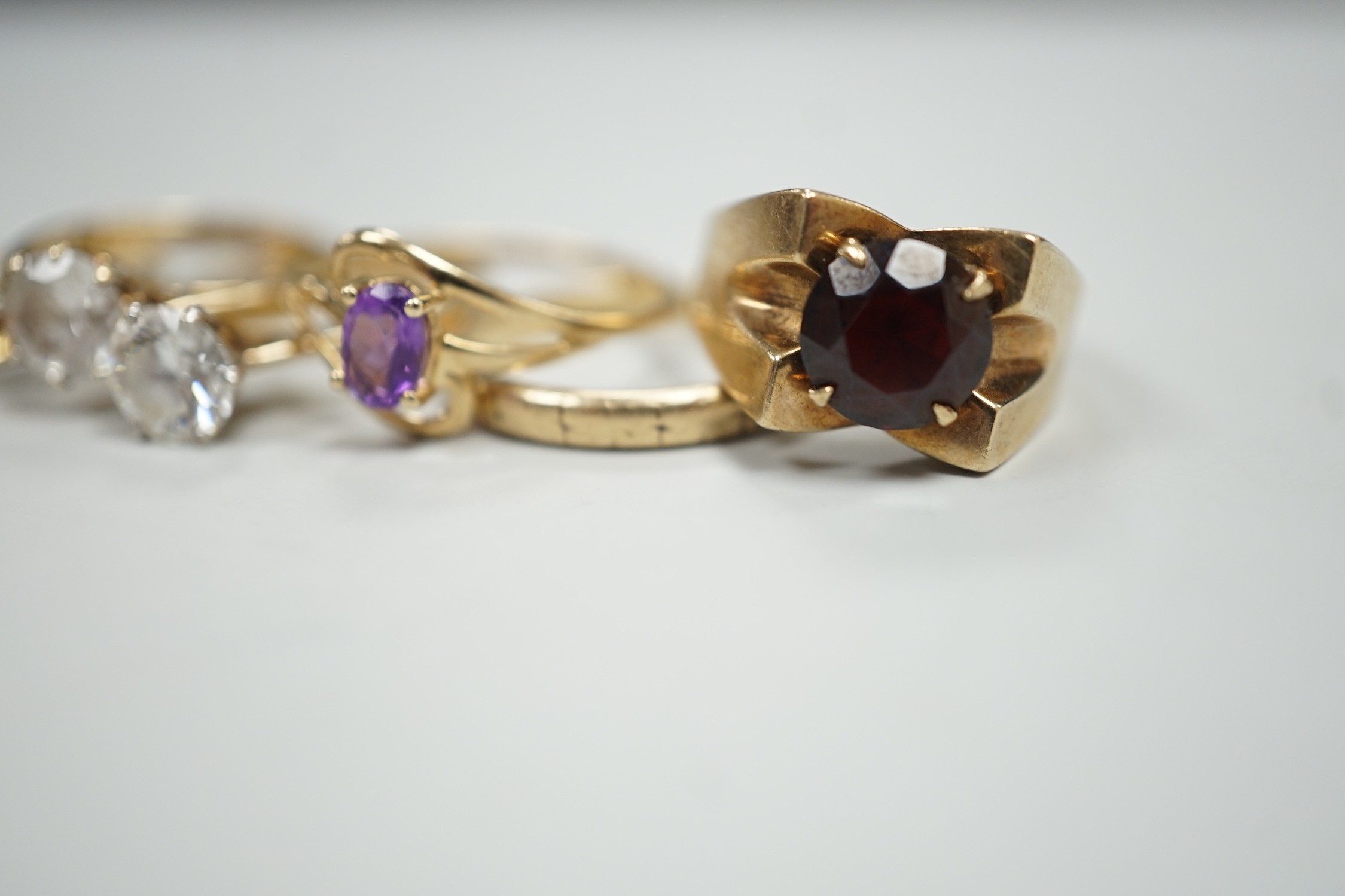 Six assorted modern 9ct gold and gem set rings, including amethyst and garnet single stone rings, together with a 9ct gold wedding band, gross weight 15.2 grams.